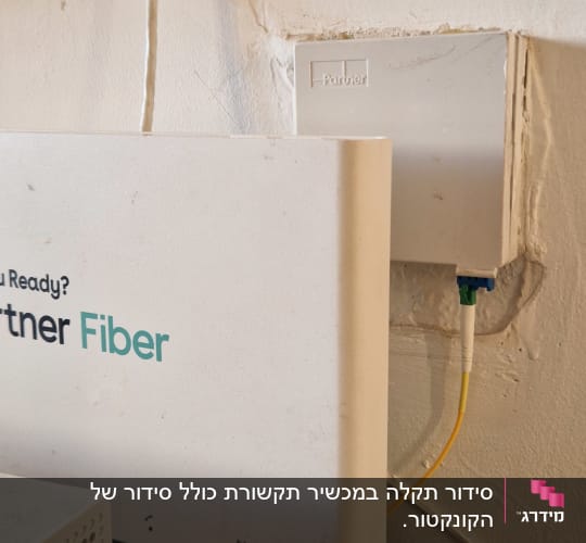 מודם סיבים אופטיים על שולחן ליד שקע חשמל